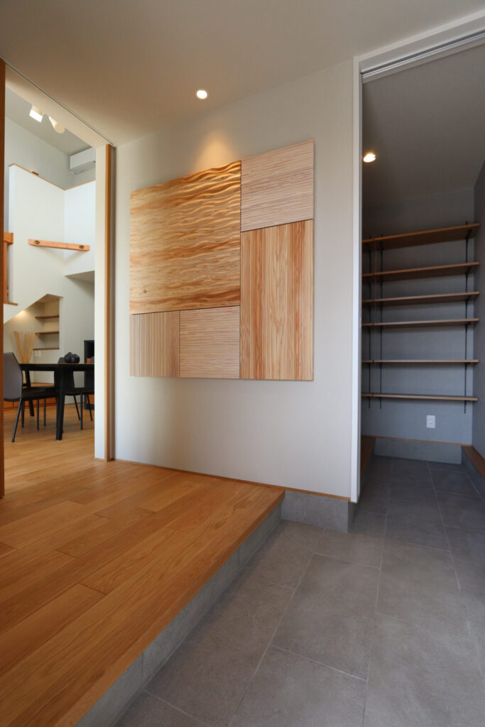 玄関で目を惹く杉のパネル