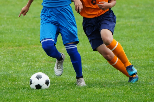 サッカー場でサッカーをする選手